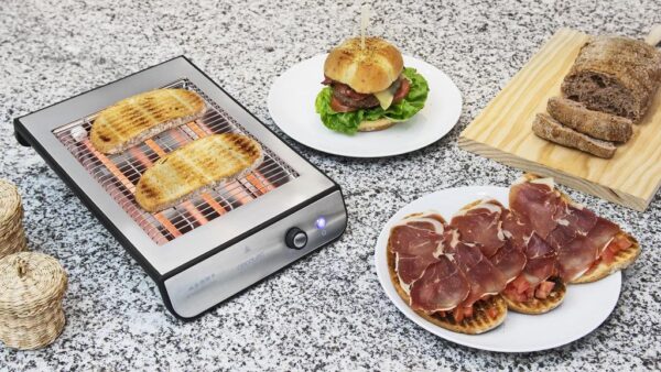 Imagen 3 Tostador plano horizontal de 900 W con acabados en acero inoxidable. Cuenta con 3 resistencias de cuarzo, 6 niveles y bandeja recogemigas para un uso eficiente.